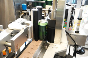 Craft beer bottles being precisely labelled by advanced Packserv Australia machinery in a brewery setting.
