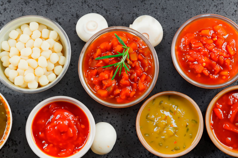 Assorted chunky sauces, soups, and relishes in glass jars